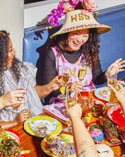 candace wearing birthday hat and everyday overalls in dinner party at a dinner party